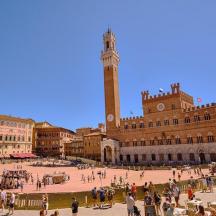 a city square with a clock tower in the background