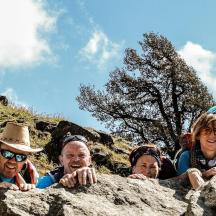 a group of people standing behind a rock