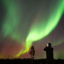 a person taking a picture of the northern lights