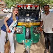 a man and a woman standing next to a motor scooter
