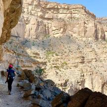 a person walking through a canyon in the mountains