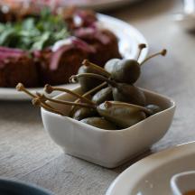 a bowl of vegetables on a table with plates of food