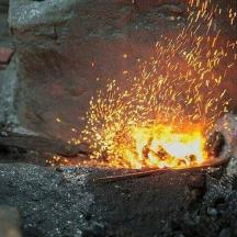 una persona que fa servir unes pinces sobre un foc
