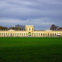 un grande edificio con un campo verde di fronte