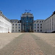 a large building with a glass building in the middle