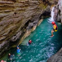 a group of people swimming in a river in a cave