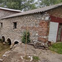 un vecchio edificio in pietra con un arco di fronte