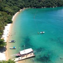 an aerial view of a beach with boats in the water