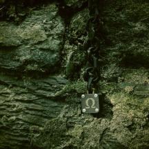 una cadena lligada a un mur de pedra amb un número