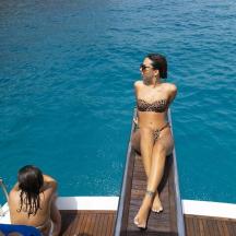 una dona en bikini asseguda en un vaixell a l'aigua