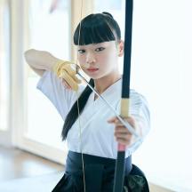 a woman is holding a bow and arrow