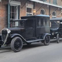 an old black car parked on the side of the street