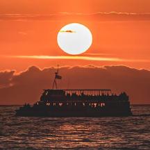 un vaixell a l'oceà amb una posta de sol al fons