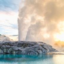 a geyser eruption with a pool of water