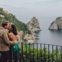 海を見下ろす岩棚でキスをする男女