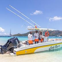 three people standing on a boat on the beach