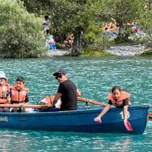 eine Gruppe von Menschen in einem blauen Boot auf einem Fluss