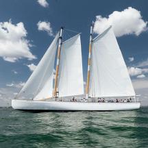 a boat with white sails in the water
