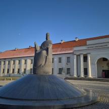 a statue in front of a large building