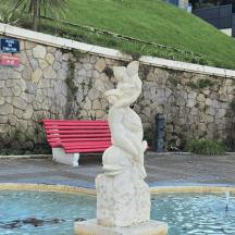 en statue af en kvinde, der står ved siden af et springvand
