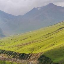 a green field with mountains in the background