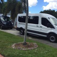 a white van is parked next to a palm tree