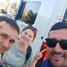 un grup de trei persoane care stau în fața unui camion