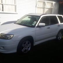 a white car parked in front of a house