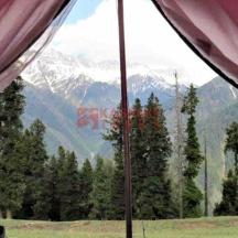 a view from inside a tent looking at a mountain
