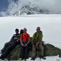 a group of people sitting on a rock in the snow