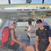 eine Gruppe von Menschen, die hinten in einem Boot sitzen