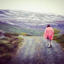 a person is walking down a dirt road