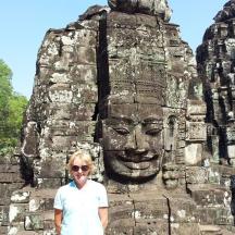 a woman standing in front of a stone temple