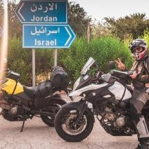 en mann som sitter på en motorsykkel ved siden av to motorsykler