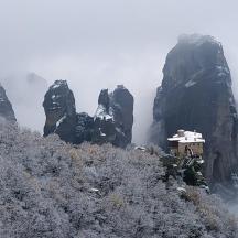 a misty mountain with a house on top of it