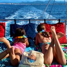 a group of girls laying on a boat in the water