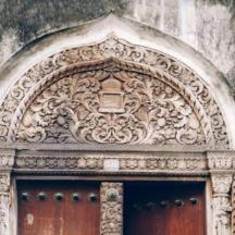 an ornate doorway with a red door in a building
