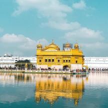 a large yellow building with its reflection in the water