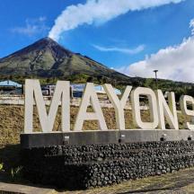 a sign with a mountain in the background
