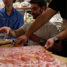 a group of people standing around a table with a cake