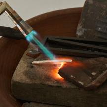 a person is lighting a match in a fire pit