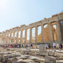 a group of people standing in front of the acropolis