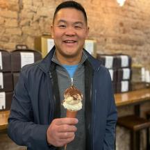 a man is holding up a ice cream cone