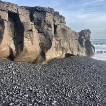 a beach with rocks and the ocean next to the ocean