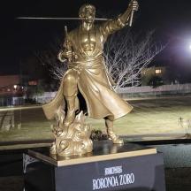una estàtua de bronze d'un home que sosté una llança