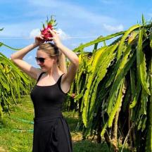 a woman in a black dress standing in a corn field