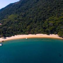an aerial view of a beach with a boat in the water