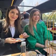 two women sitting at a table with plates of food