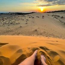a person laying in the sand in the desert