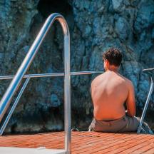 a man sitting on the edge of a pool